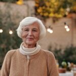 Cheerful senior woman in a cozy cardigan enjoying an outdoor gathering in the garden.